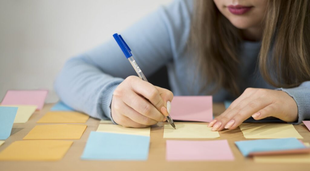front view woman writing sticky notes office scaled 1 front view woman writing sticky notes office scaled 1