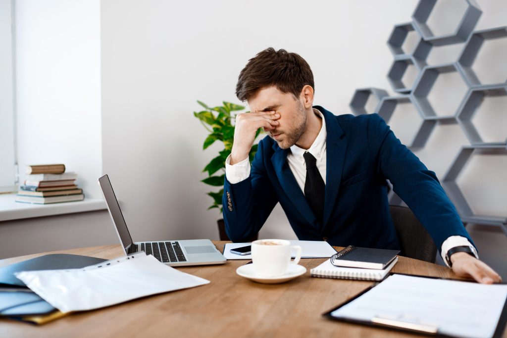 upset young businessman sitting workplace office background scaled 1 upset young businessman sitting workplace office background scaled 1