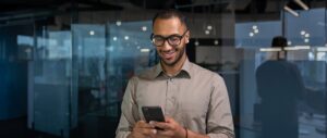 smiling african american businessman inside office shirt using phone man typing message smiling african american businessman inside office shirt using phone man typing message