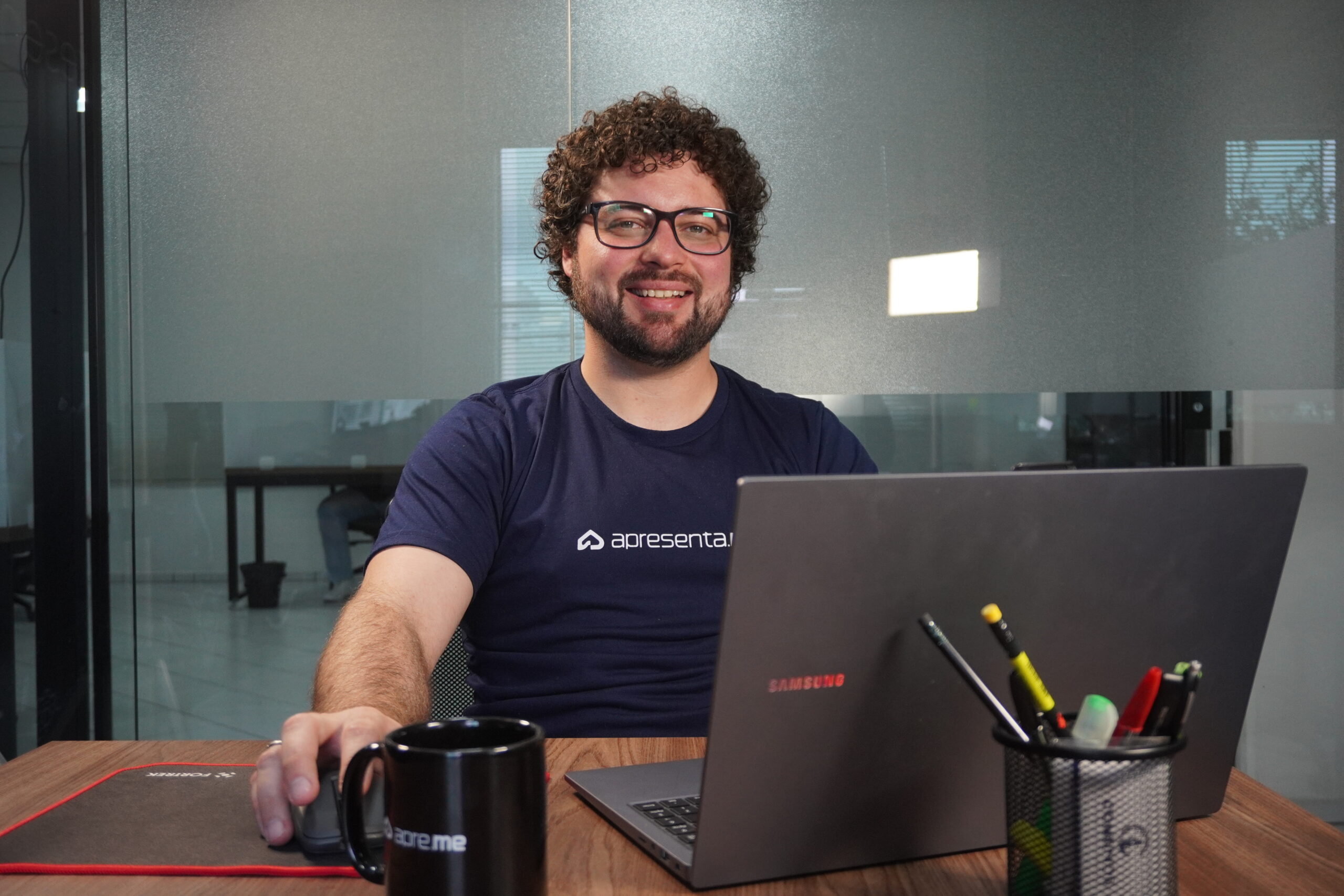 Especialista do time de Sucesso do Cliente da Apresenta.me sorrindo em frente ao notebook