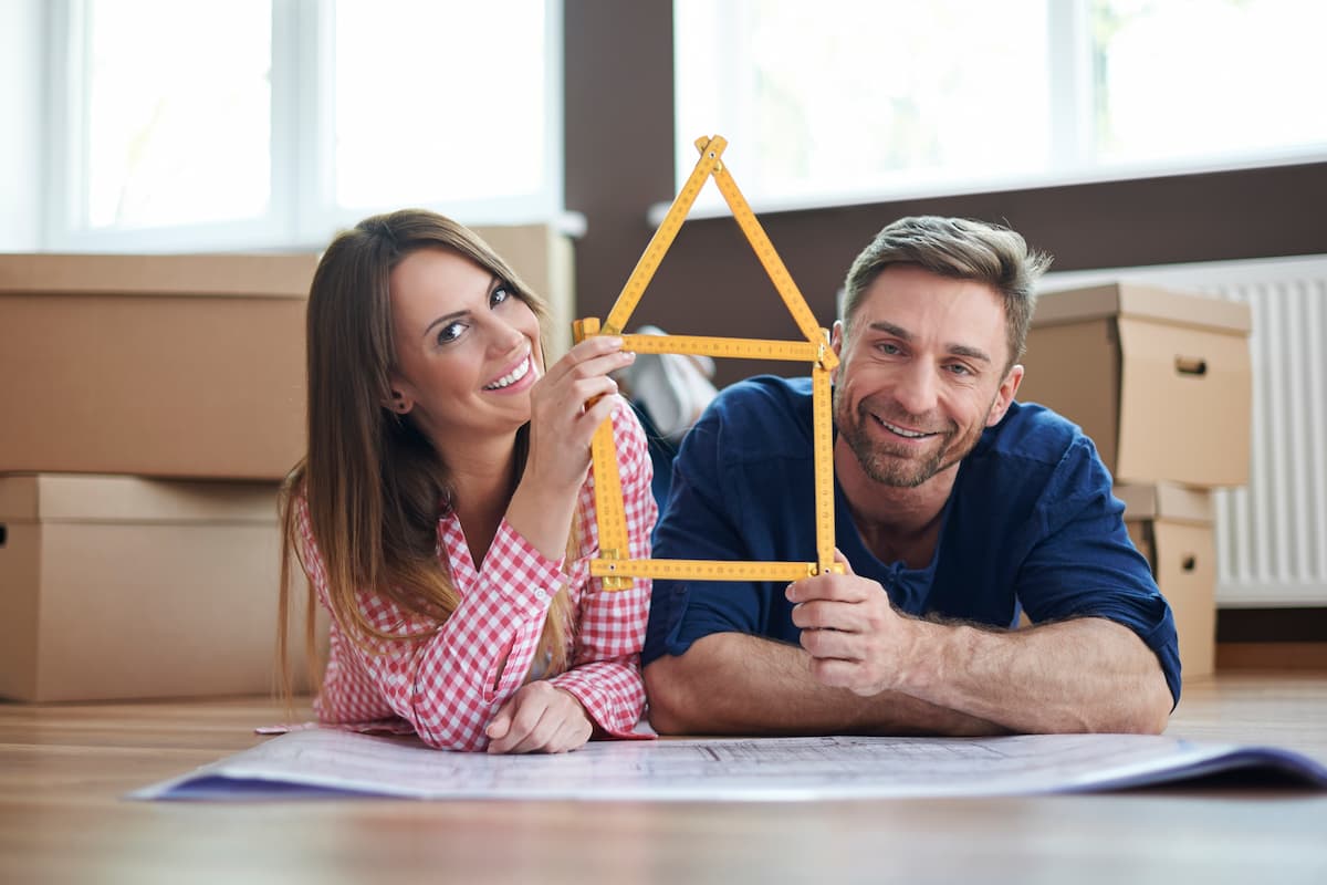 casal segurando objeto em forma de casa