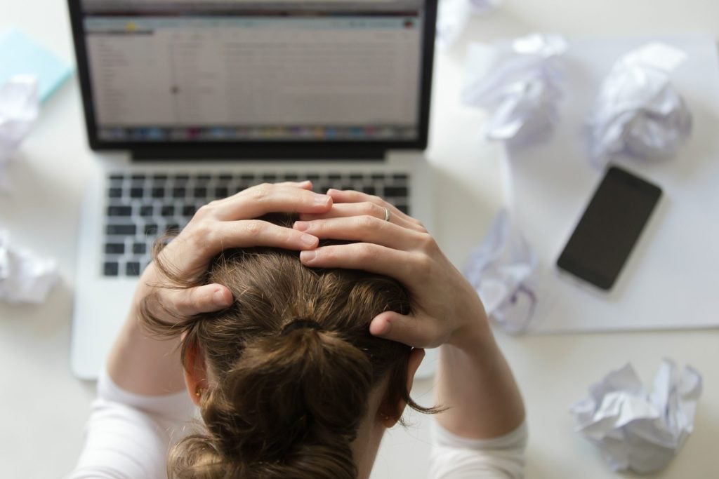 portrait woman grabbing head desk near laptop scaled 1